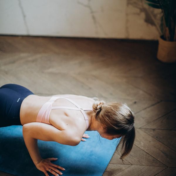 Woman in a calming yoga pose in a dark room.